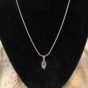 This is a sterling silver necklace with a diamond chip in the pendant.